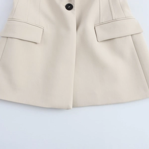 Detail of beige blazer flap pockets and button with premium woven fabric texture