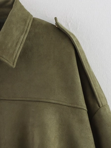 Close-up of olive green suede jacket featuring lapel collar and epaulette detail
