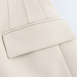 Detail of the high-quality flap pocket and fine vertical stitching on the cream suit blazer