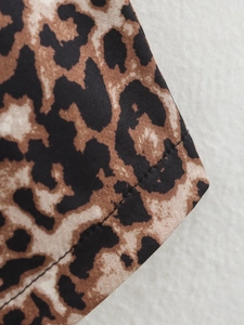 Close-up of leopard print vest showing fine woven fabric texture and stitching detail