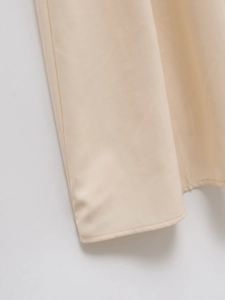 Close-up of beige woven twill fabric hem with uniform stitching and solid texture