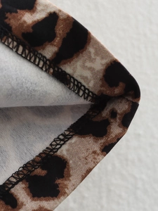 Close-up of high-quality leopard print vest showing neat stitched edges and fabric texture