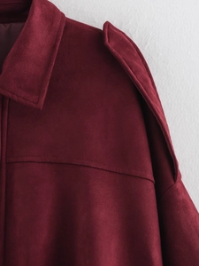 Close-up of burgundy faux suede flight jacket featuring epaulets and fine stitching
