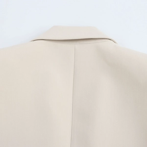 Close-up of lapel collar stitching and twill texture on beige long sleeve blazer set