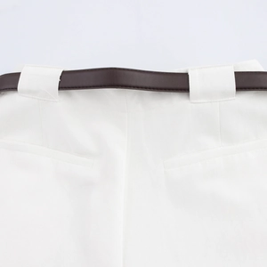 Detail einer weißen Hose mit hoher Taille, strukturiertem Stoff und schmalem braunem Ledergürtel