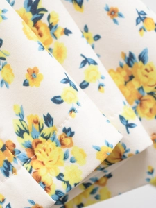 Floral print v-neck backless dress featuring yellow and blue blossoms on white fabric