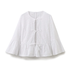 Detail of white eyelet embroidery blouse with ribbon ties and flare sleeve design