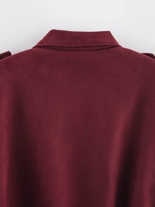 Detail of burgundy suede bomber jacket showing collar stitching and premium fabric texture