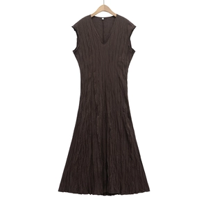 Detailed view of the dark brown V-neck dress featuring vertical pleat textures and fabric