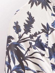 Détail de l'imprimé feuilles tropicales sur tissu ivoire lisse pour une robe d'été à col V