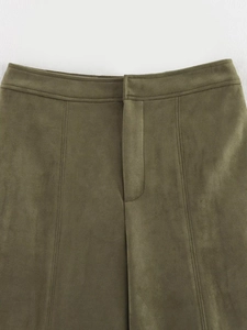 Macro detail of dark olive green faux suede fabric texture and neat stitching on waistband