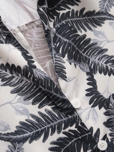 Gros plan détaillé du col à revers et imprimé fougère sur robe chemise en coton