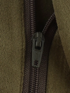 Close-up of the metal zipper detail and faux suede texture on dark green bomber jacket