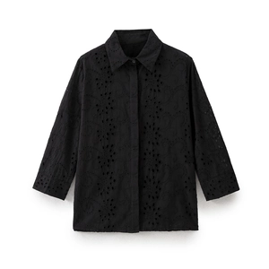 Detail of black embroidered shirt with Broderie Anglaise hollow patterns and collar