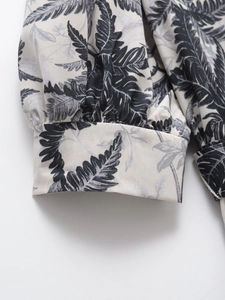 Détail du poignet avec imprimé feuilles tropicales noir et blanc sur tissu tissé
