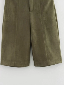 Detail of olive green suede shorts featuring premium texture and vertical seam stitching