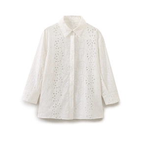 Detailed view of intricate floral eyelet embroidery on white long sleeve shirt fabric