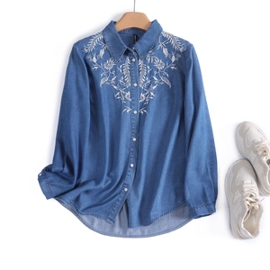 Detail of floral embroidery on a vintage wash blue denim shirt for women