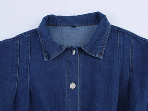 Detailed close-up of dark blue denim collar with orange stitching and silver buttons