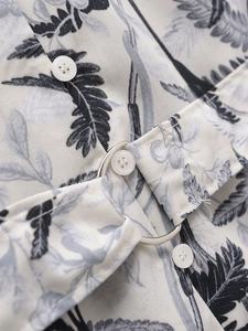 Détail de robe imprimée montrant des boutons blancs et une ceinture à boucle en D métal