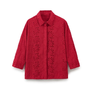 Close-up of red hollow embroidery and floral Broderie Anglaise texture on the shirt