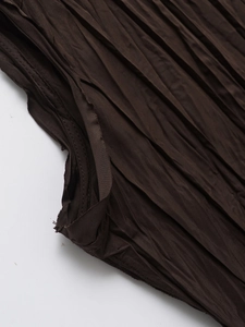 Detailed macro view of deep brown pleated fabric showing fine texture and raw cut edges