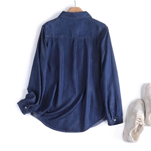 Detail view of the inverted pleat on the back of this dark blue denim shirt for women