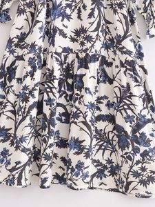 Détail de l'imprimé floral bleu sur tissu blanc avec poignets élastiques à smokings