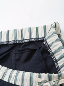 Detailed close-up of elastic high waist with stripe trim and reinforced stitching