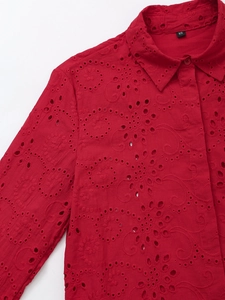 Detail of red hollow embroidery pattern and lapel collar on loose casual blouse shirt