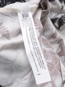 Détail de l'étiquette 100% coton et de l'imprimé feuilles sur le col de la robe chemise