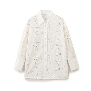 Detail of white long sleeve shirt showing intricate hollow floral embroidery and button cuffs