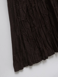 Close-up of dark brown dress fabric showing detailed crinkled texture and vertical stitching