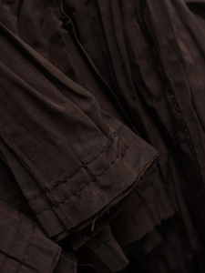 Macro detail of fine pleats and double stitching on the sleeve of this V-neck sleeveless dress