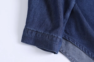 Close-up of deep blue denim fabric texture and precise stitching on the vintage shirt