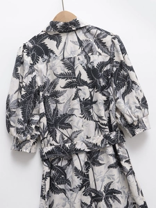 Détail de robe à imprimé feuilles tropicales avec col à revers et ceinture assortie