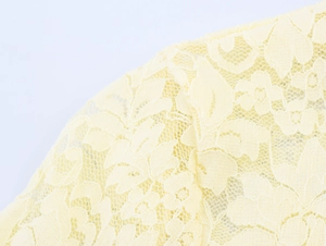 Gros plan sur le tricot de dentelle jaune clair avec motifs floraux crochetés