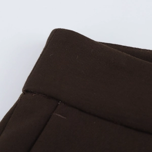 Vue macro des coutures du tissu marron de qualité sur la taille du pantalon taille haute
