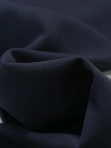 Detailed close-up of navy blue striped fabric showing fine twill texture and drape