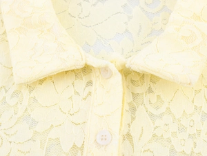Détail du haut en dentelle jaune clair avec col classique et boutons élégants