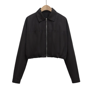 Detail of black zip-up cropped jacket featuring lapel collar and elastic waistband hem