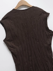 Detail shot of a dark coffee sleeveless top featuring fine vertical pleated texture