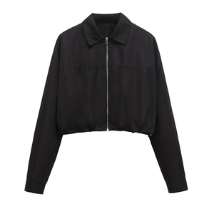 Detail of black short jacket featuring silver metal zipper and elastic hemline