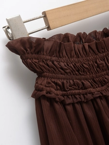 Detail of the elastic high waist with ruffled edges on a dark brown summer skirt