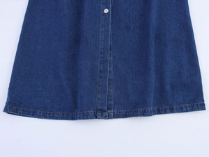 Detailed view of dark blue denim dress featuring orange contrast stitching and silver button