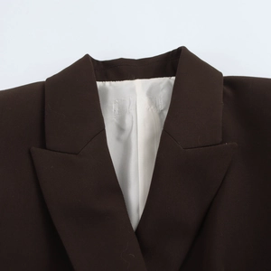 Détails du revers à pointe et des épaulettes d'un blazer croisé marron foncé