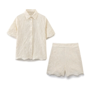 Close-up of cream floral embroidery on a short-sleeved shirt and matching shorts set