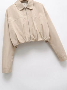 Detailed view of the metal zipper and lapel collar on this beige casual short jacket