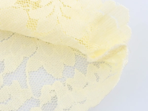 Vue macro du tricot de dentelle jaune clair avec motifs floraux et maille ajourée