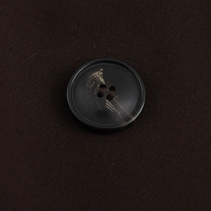 Détail macro de boutons noirs à motif marbré sur le tissu d'un blazer vintage